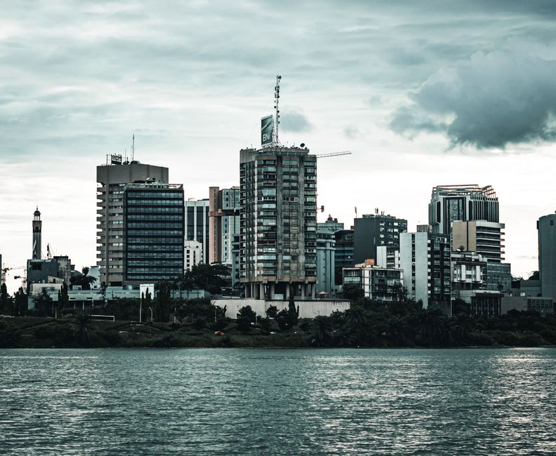 Quartier d'affaires d'Abidjan vu depuis la lagune, immeubles de bureaux modernes reflétés dans l'eau