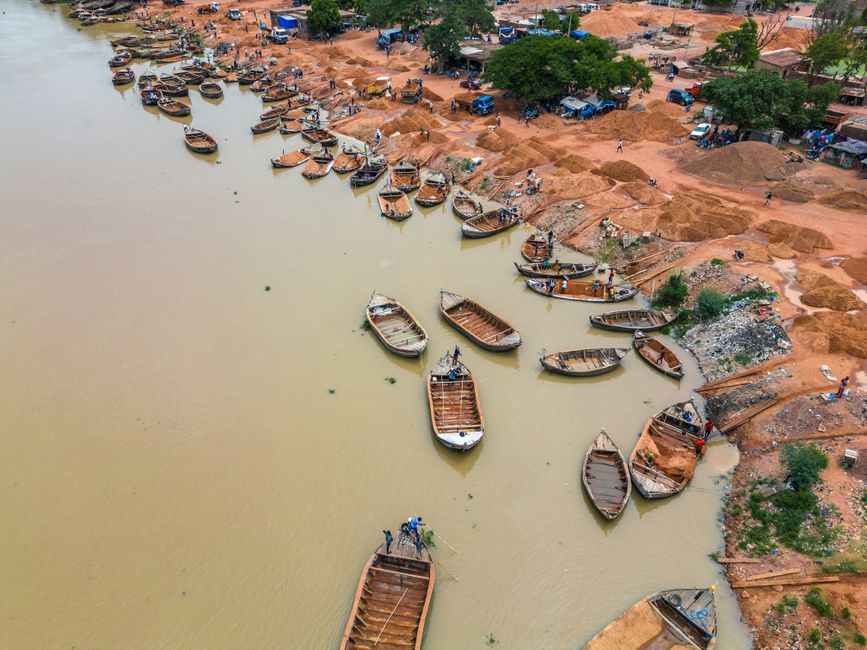 Vue aérienne de pirogues traditionnelles sur le fleuve Niger avec des rives de sable rouge, Mali
