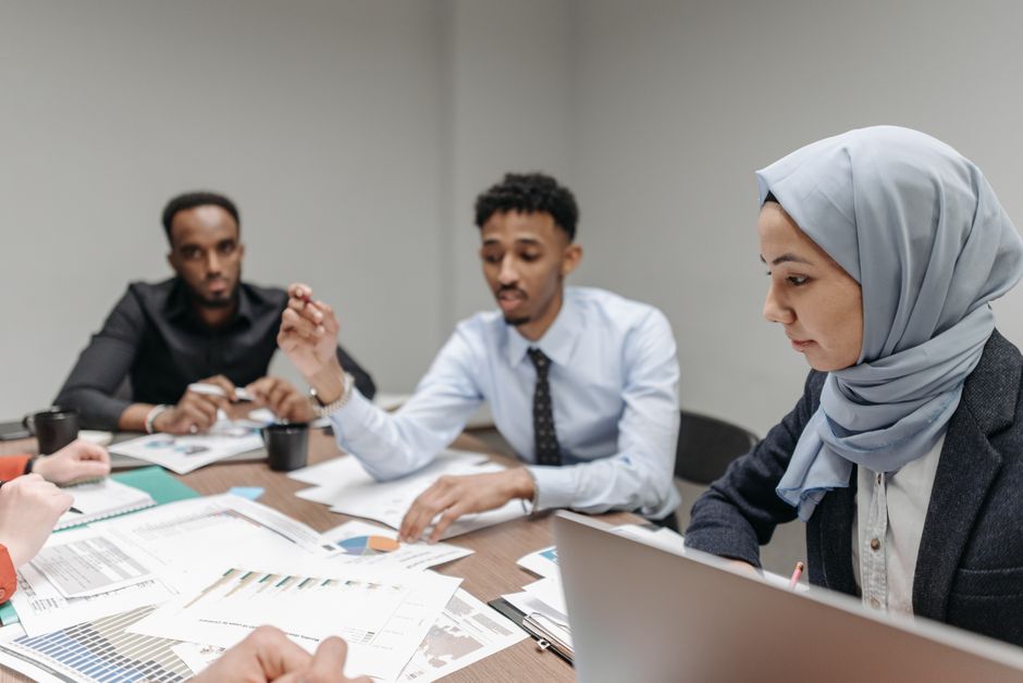 Équipe multiculturelle de professionnels réunis autour d'une table avec des documents et graphiques pour un appel d'offres